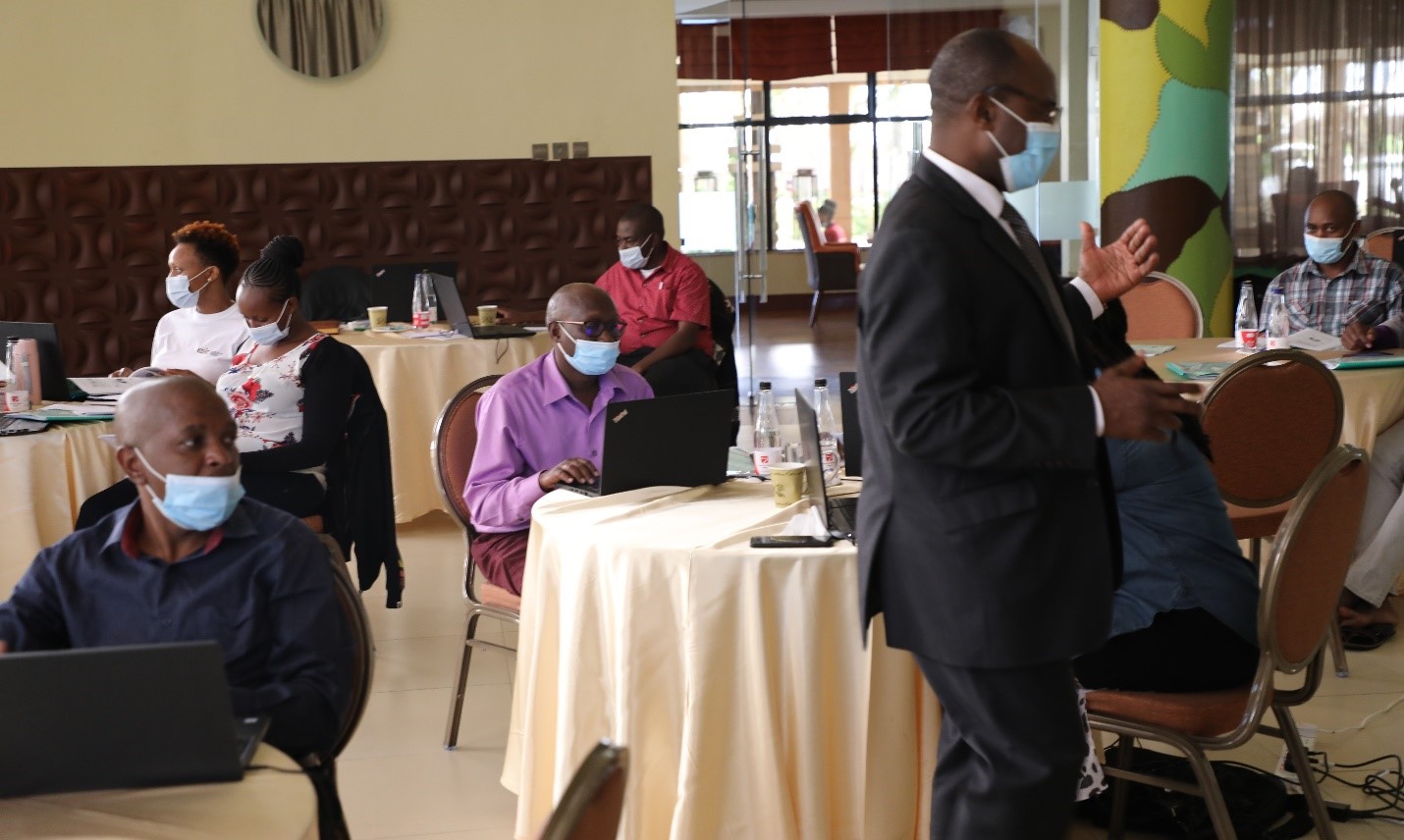 A section of staff alongside the independent consultant pose for a group photo during a previous session on QMS